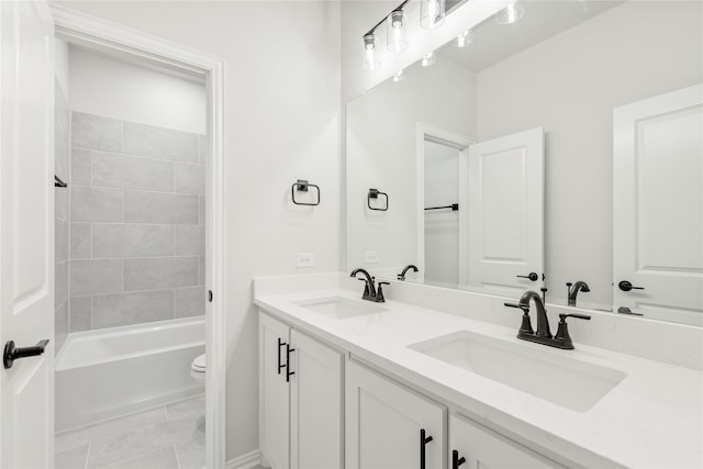 full bathroom featuring tile patterned floors, toilet, vanity, and tiled shower / bath combo