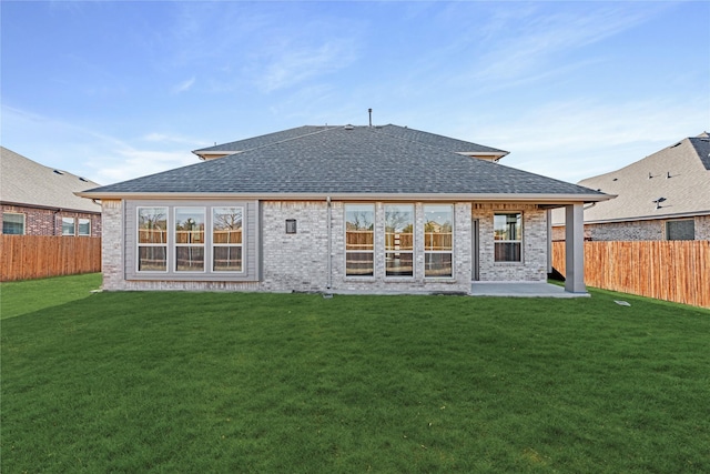 back of house featuring a lawn and a patio area