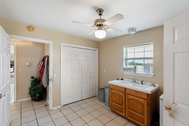 interior space with a ceiling fan, a sink, and light tile patterned floors