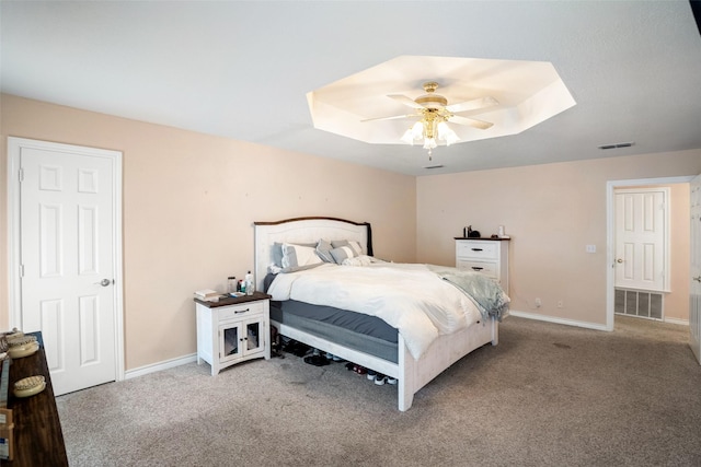 bedroom featuring carpet floors, ceiling fan, and a tray ceiling