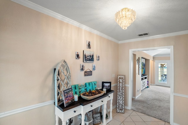 hall with light tile patterned floors, light carpet, an inviting chandelier, ornamental molding, and visible vents