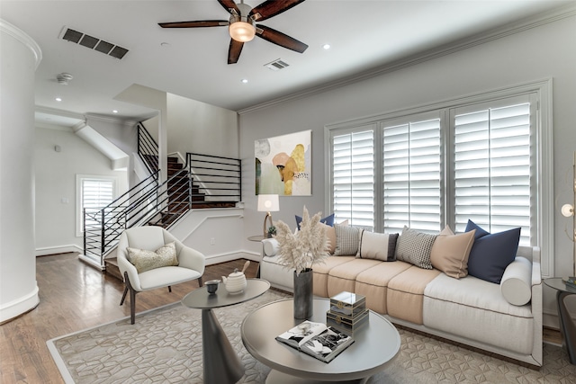 living room featuring light hardwood / wood-style floors, crown molding, and ceiling fan