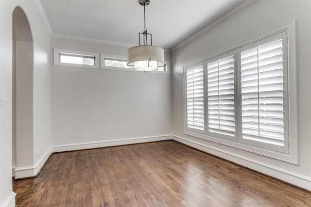 empty room featuring crown molding, a healthy amount of sunlight, and dark hardwood / wood-style flooring