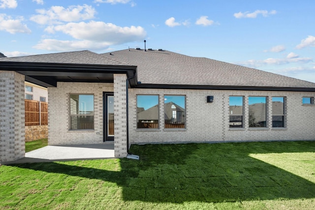 rear view of property with a yard and a patio