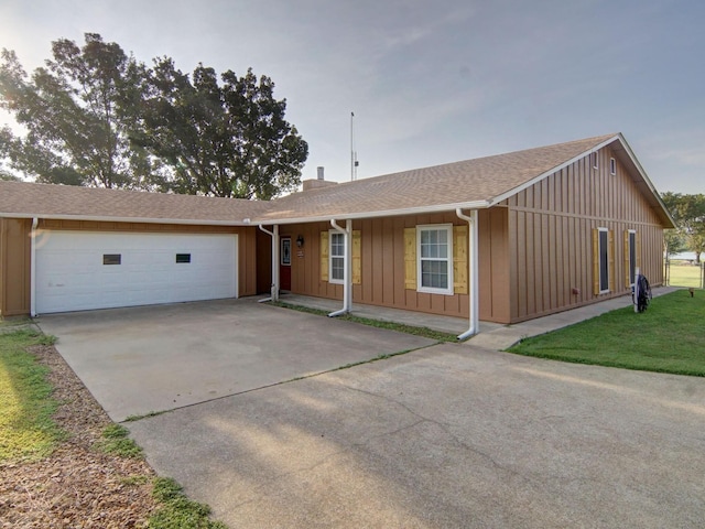 ranch-style house featuring driveway, a shingled roof, board and batten siding, and an attached garage