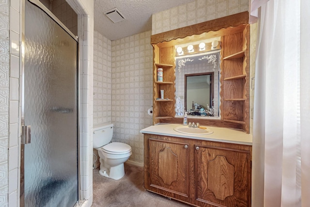 bathroom with a textured ceiling, vanity, visible vents, a stall shower, and wallpapered walls