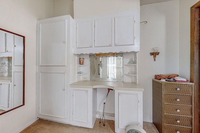 kitchen featuring light colored carpet, white cabinetry, baseboards, light countertops, and open shelves