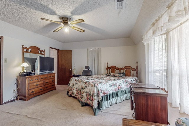 bedroom with light carpet, a textured ceiling, visible vents, and a ceiling fan