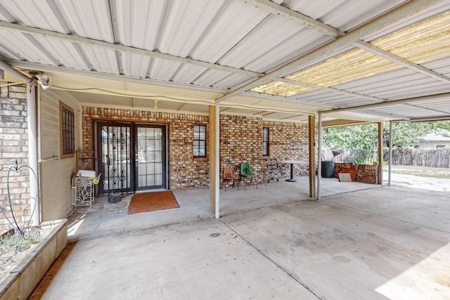 view of patio / terrace with an attached carport and fence