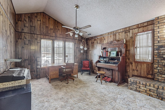 office area featuring vaulted ceiling, wood walls, a textured ceiling, and light carpet