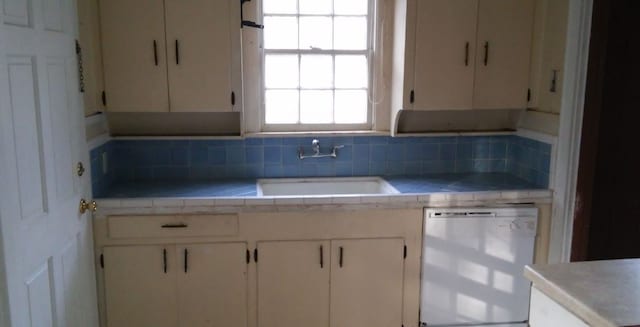 kitchen with white cabinetry, sink, tasteful backsplash, and dishwasher