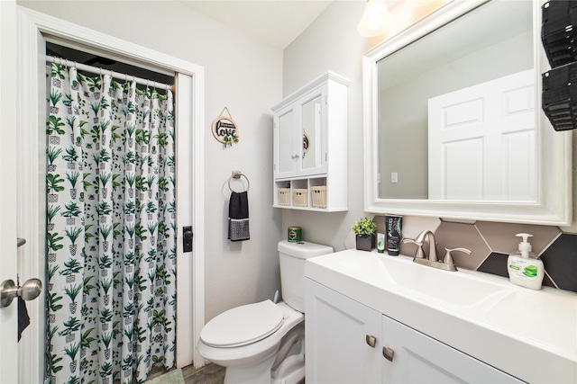 bathroom with vanity, decorative backsplash, and toilet