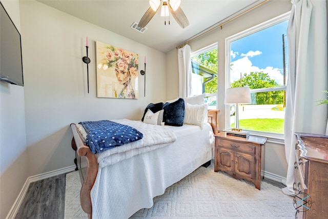 bedroom with multiple windows, ceiling fan, and light wood-type flooring