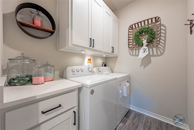 laundry area with cabinets, washing machine and clothes dryer, and dark hardwood / wood-style flooring