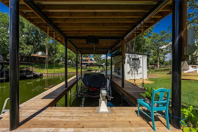 view of dock with a water view and a yard