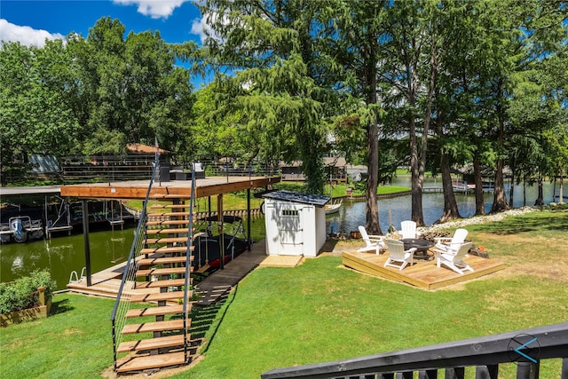 view of yard featuring a deck with water view and a storage shed