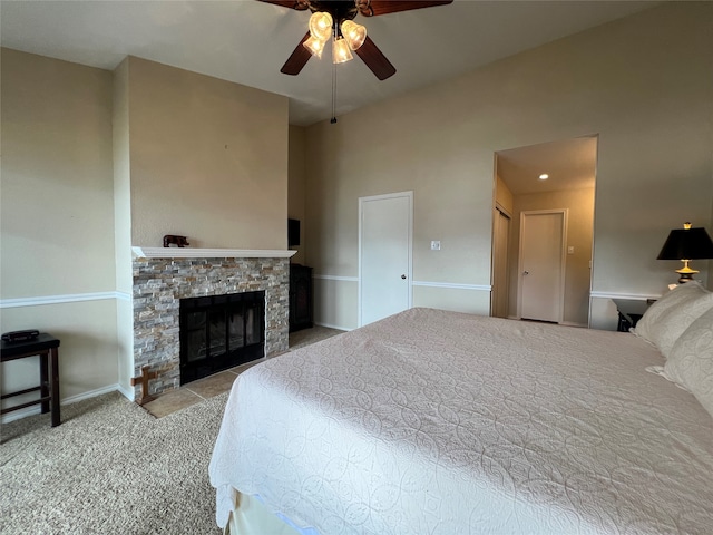 bedroom with light colored carpet, a fireplace, and ceiling fan