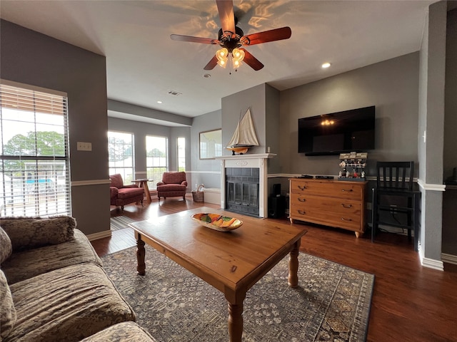 living room featuring dark wood-type flooring and ceiling fan