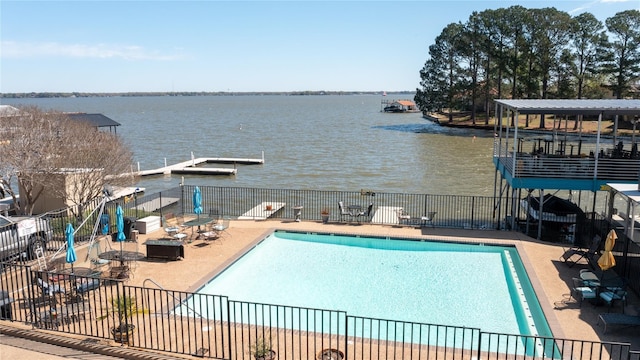 view of swimming pool featuring a patio area, a water view, and a fire pit