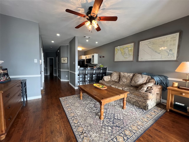 living room with dark hardwood / wood-style flooring and ceiling fan