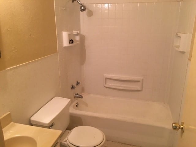 full bathroom with toilet, tiled shower / bath, and vanity