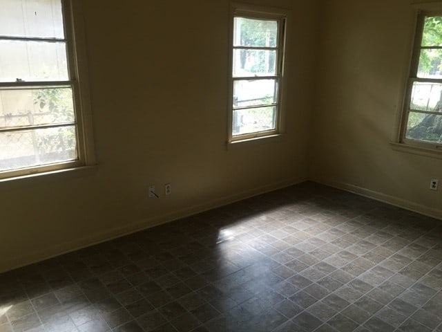 tiled spare room featuring a healthy amount of sunlight