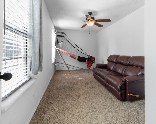 carpeted living room featuring a textured ceiling and ceiling fan