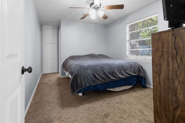 bedroom featuring a textured ceiling, carpet, and ceiling fan