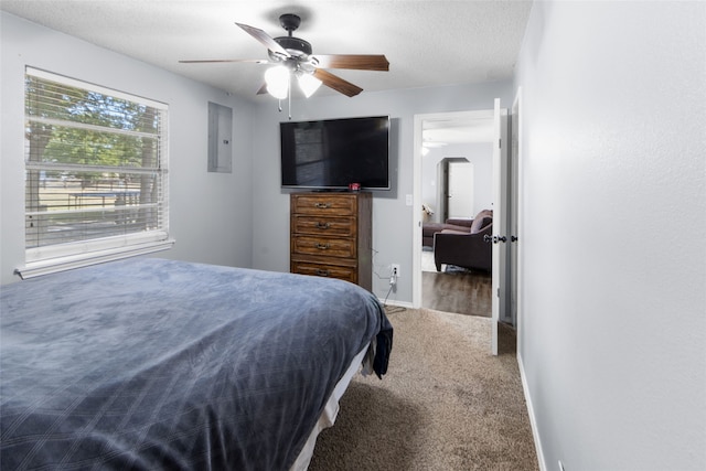 carpeted bedroom with electric panel, ceiling fan, and a textured ceiling