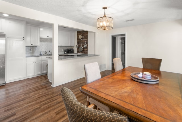 dining area featuring dark wood-type flooring, a notable chandelier, and sink