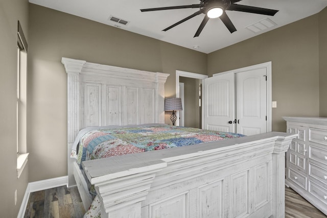 bedroom featuring a ceiling fan, baseboards, visible vents, and wood finished floors