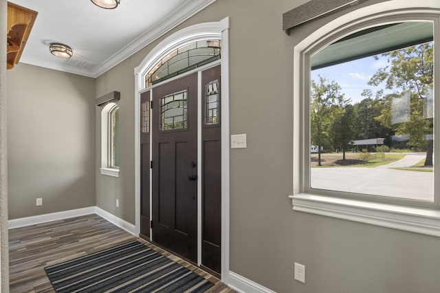 entrance foyer featuring baseboards, crown molding, and wood finished floors