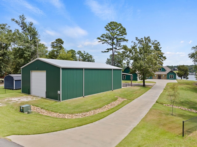 view of side of property featuring a garage, a yard, and an outbuilding