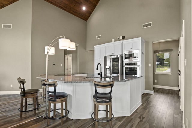 kitchen featuring stainless steel appliances, stone counters, a sink, and visible vents