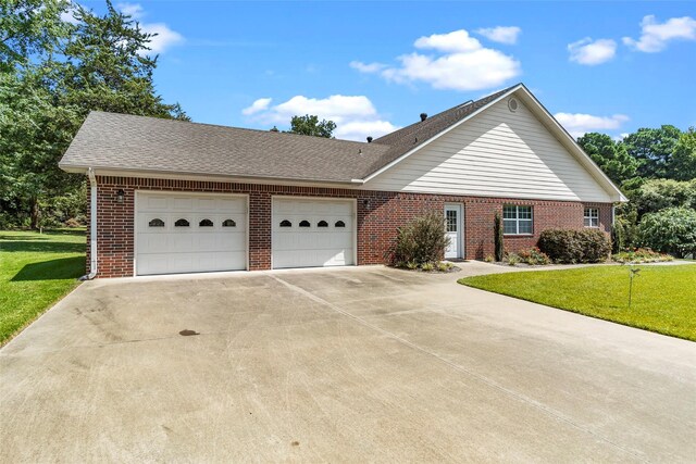 ranch-style home featuring a garage and a front lawn