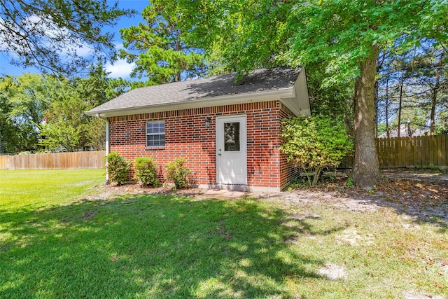 view of outdoor structure with fence and an outbuilding