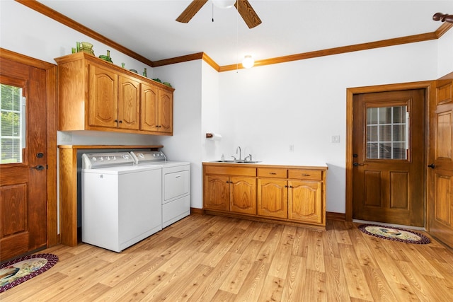 washroom featuring cabinet space, washer and clothes dryer, ornamental molding, light wood-style floors, and a sink