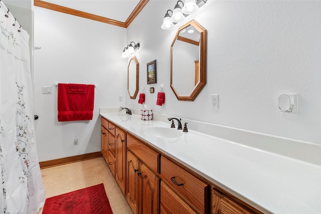 bathroom featuring double vanity, crown molding, baseboards, and a sink