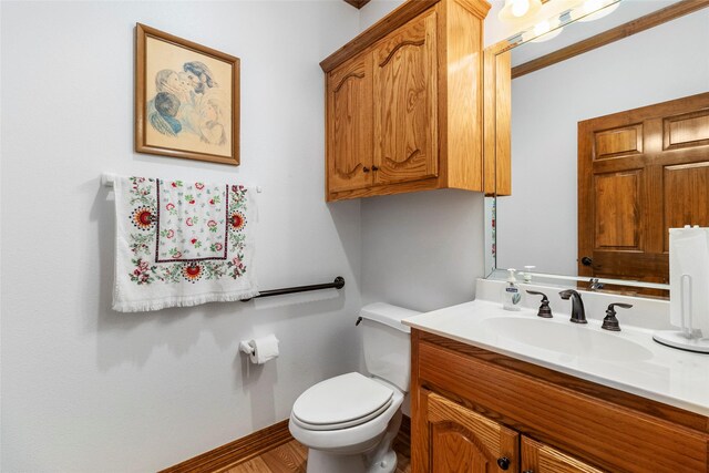 bathroom with wood-type flooring, vanity, and toilet