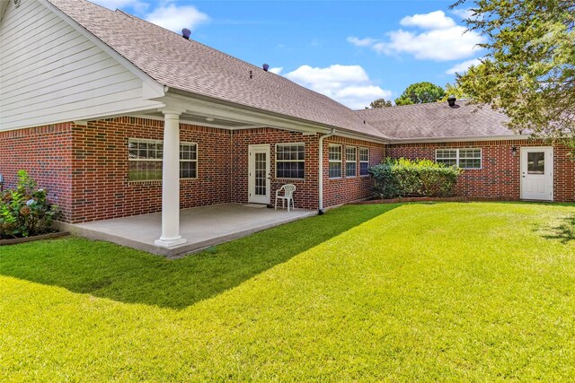 back of property with a lawn and a patio area