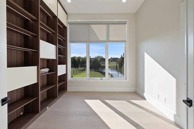 empty room featuring light hardwood / wood-style flooring and a water view