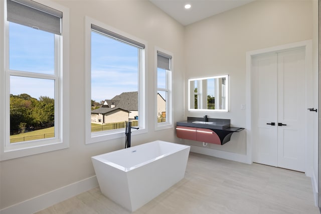 bathroom featuring a tub to relax in and sink