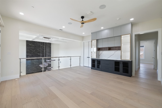 unfurnished living room featuring beamed ceiling, ceiling fan, and light hardwood / wood-style flooring