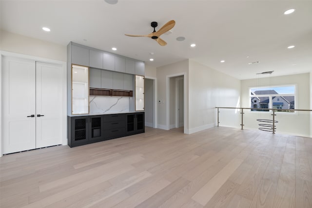 unfurnished living room featuring ceiling fan and light hardwood / wood-style flooring