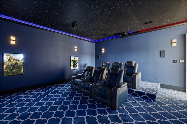 carpeted home theater room featuring crown molding