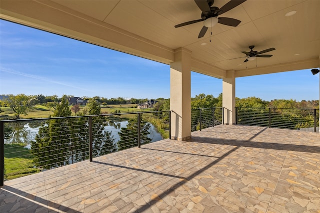 view of patio featuring a water view, a balcony, and ceiling fan