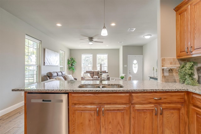 kitchen featuring kitchen peninsula, dishwasher, light hardwood / wood-style floors, and sink