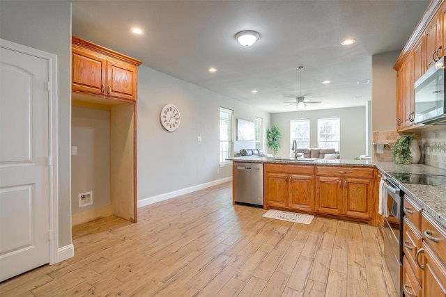 kitchen with stainless steel appliances, decorative backsplash, light hardwood / wood-style floors, and kitchen peninsula