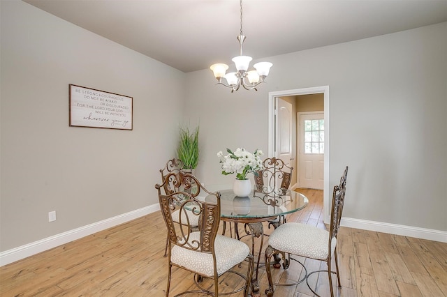 dining room with a notable chandelier and light wood-type flooring