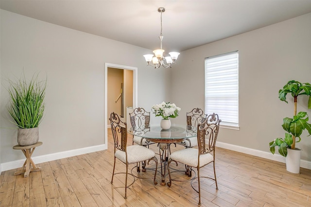 dining space with a chandelier and light hardwood / wood-style flooring